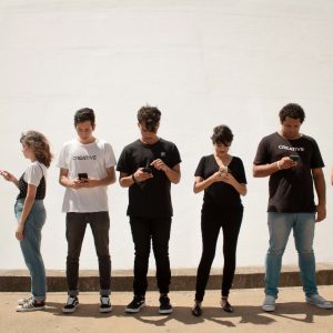 Grupo de personas concentradas en sus celulares, simbolizando el concepto de Social listening y la importancia de las interacciones digitales.
